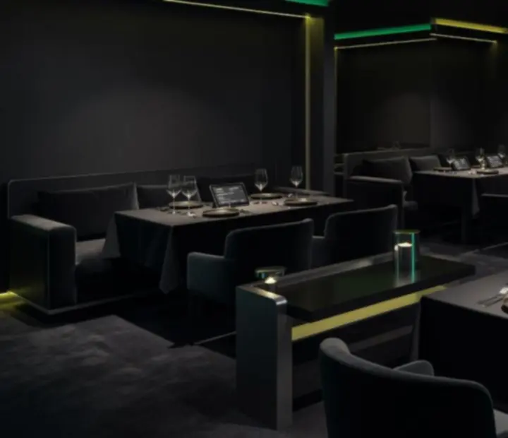 Ciemna, elegancka aranżacja stołów w restauracji Novastrefario z subtelnym neonowym oświetleniem